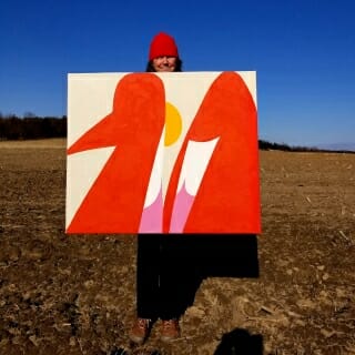 Guzzo Pinc standing behind painting in barren field