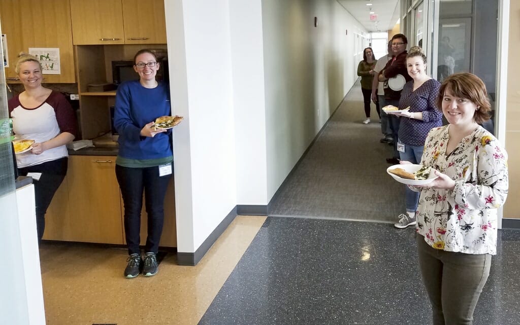 Employees at the Wisconsin State Laboratory of Hygiene take a break to enjoy pizza. The lab has conducted extensive testing for COVID-19, and employees have continued to report to work.