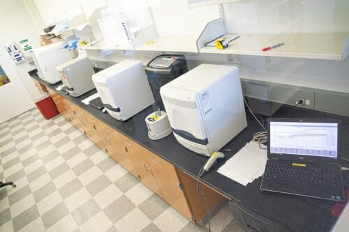 Testing machines on lab bench next to laptop computer