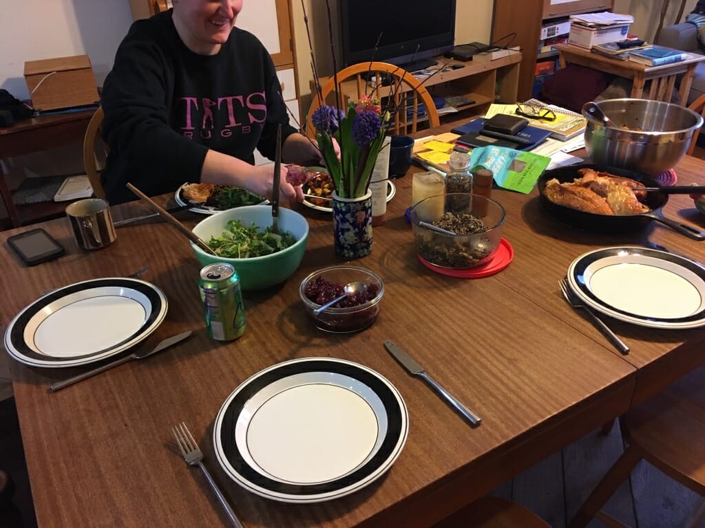 Person placing plate of food on dining table