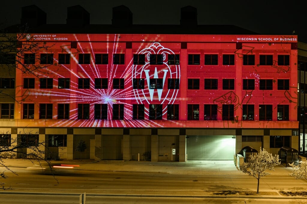 A building with names projected upon it at nighttime.