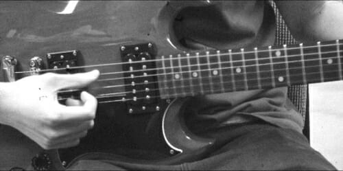 Closeup of a person's hand strumming a guitar