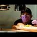 Food worker wearing a mask while preparing food order.