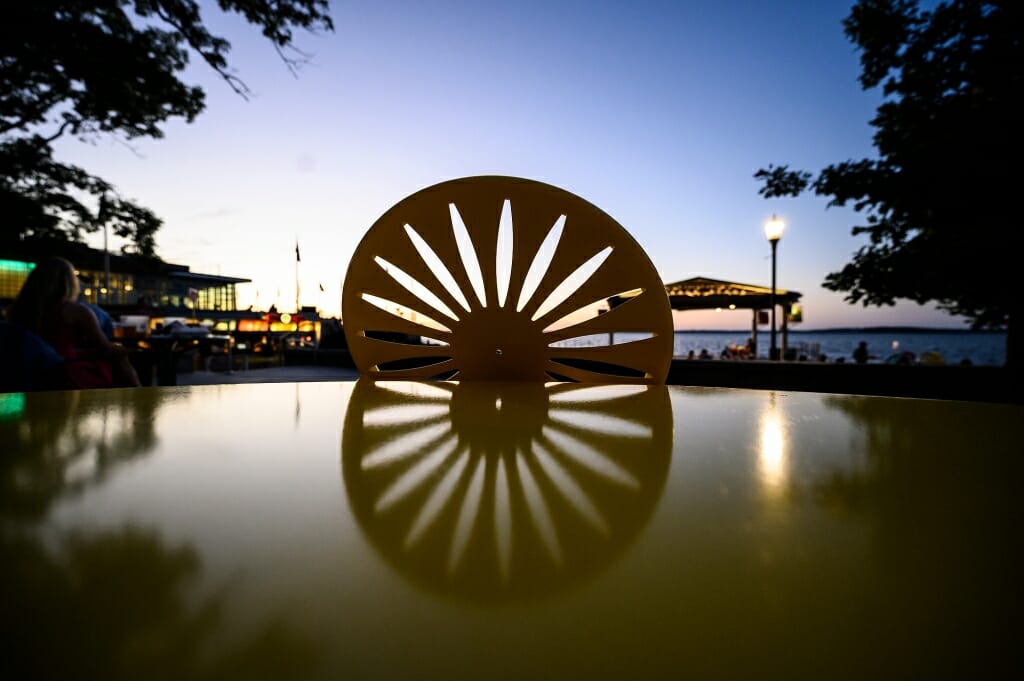 A sunburst chair pattern is reflected on a table in the sunset light.