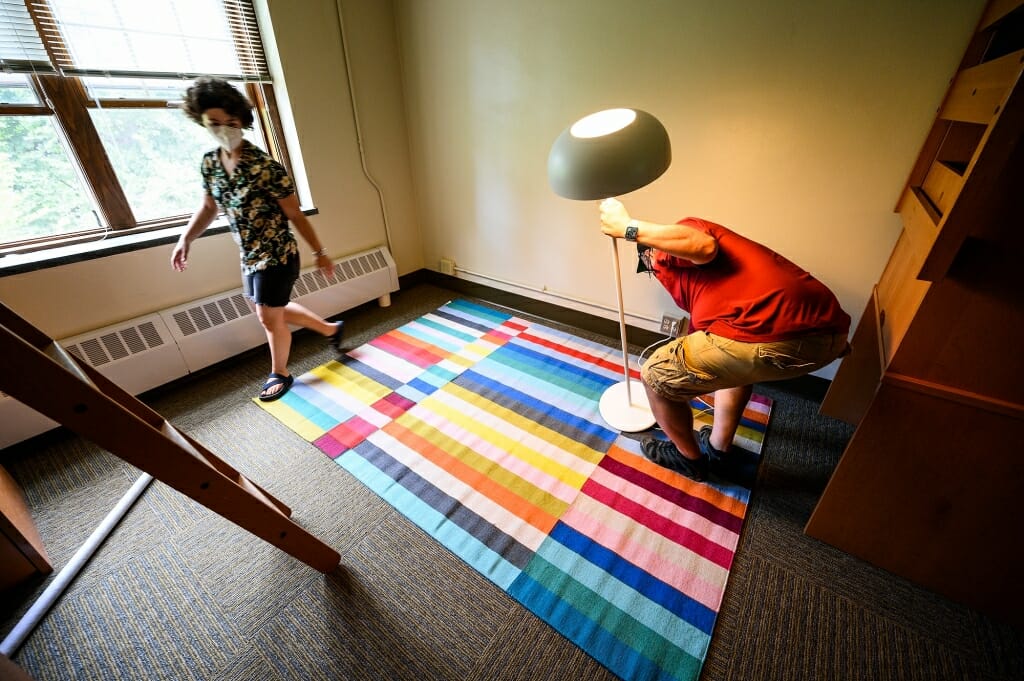A brightly colored rug and a lamp add a touch of home to Bella Rosenberg's residence hall room.