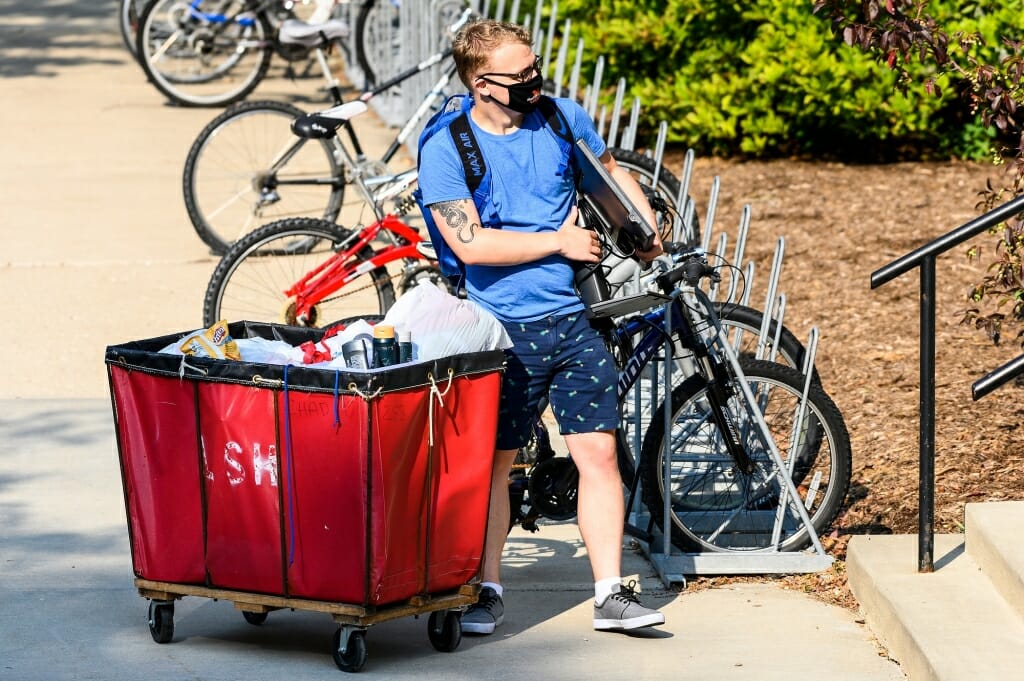 A student unloads a cart while moving in to one of the lakeshore residence halls.