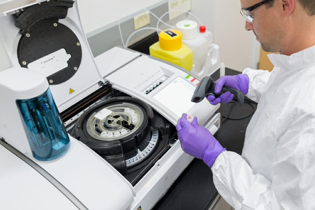 Man scanning cell culture in vial