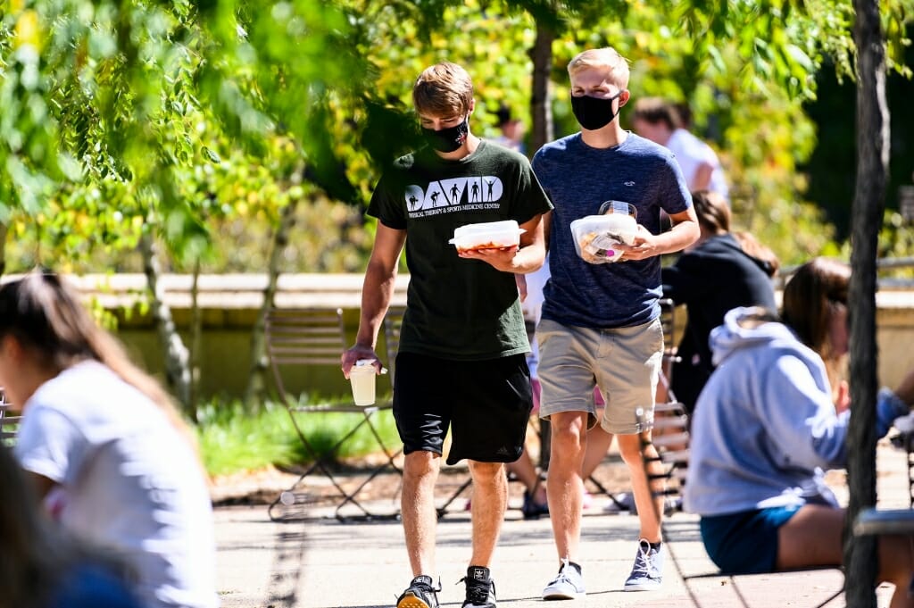 Two men walk with carry out food orders from Gordon Dining and Event Center on the first day of classes.