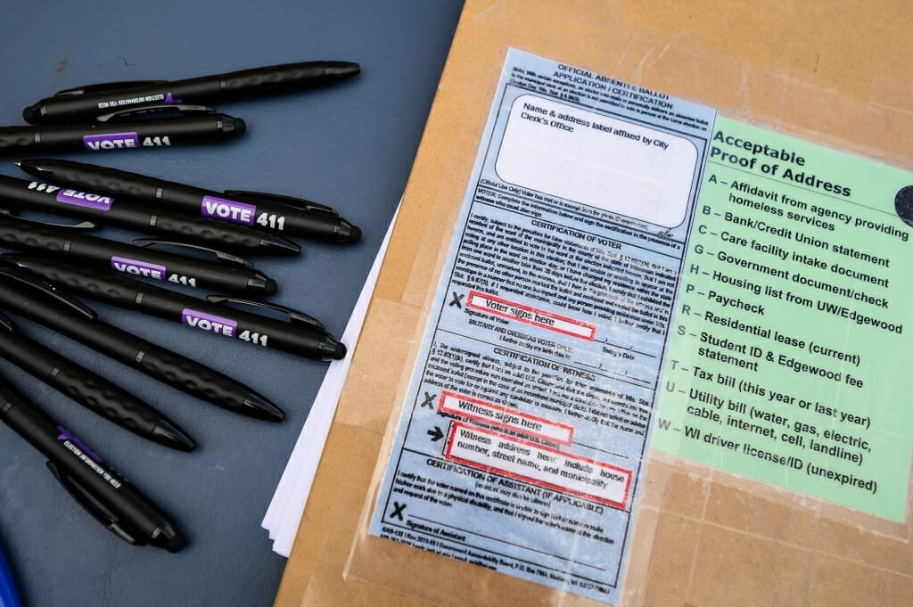 Pens and a clip board with instructions for how to register to vote are ready for students.