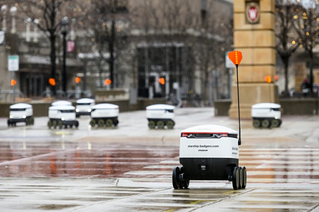 Several food delivery robots on the sidewalk