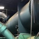 A large tank and pipes form a chiller unit in a power plant