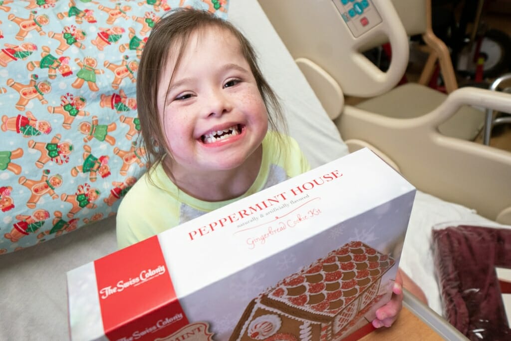 Livi Witte, 8, of Monona, shows off a gingerbread house cookie kit, a gift, along with a new blanket, that Santa gave to each patient. 