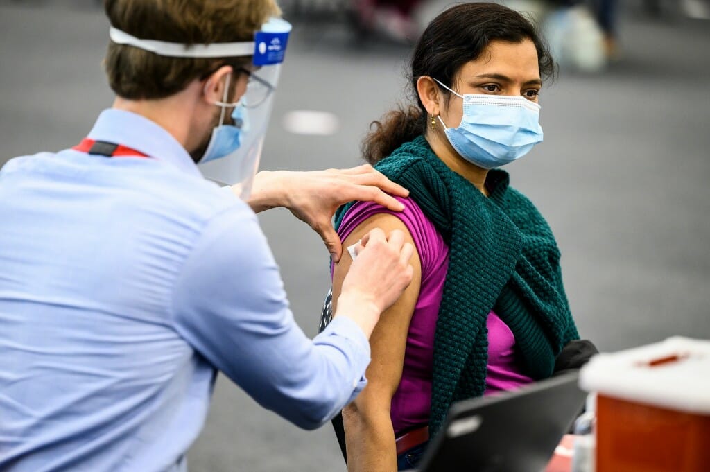 Photo of University Health Service physician assistant Patrick Bohn vaccinating Garima Singh.