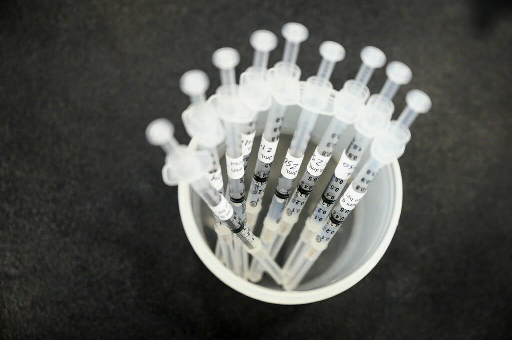 A cup containing syringes