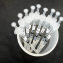 A cup containing syringes