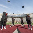 The UW-Madison senior class officers in their commencement gowns in Camp Randall Stadium on March 9. Pictured left to right are Alec Bukowiec, senior class president; Lusayo Mwakatika, senior class philanthropy director; Paige Schultz, senior class vice president; and Dalila Ricci, senior class events director. Not pictured is Calli Hughes, communications director.