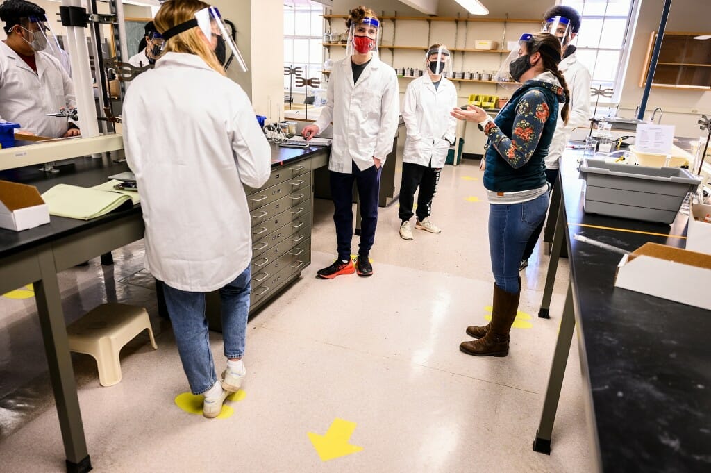 At right, Amanda Buchberger, an assistant faculty associate, checks in with undergraduate students conducting experiments in Chemistry 329: Fundamentals of Analytical Science, taught in the Medical Sciences Center on March 1. The class is one of the largest in-person labs being taught during the Spring 2021 semester.