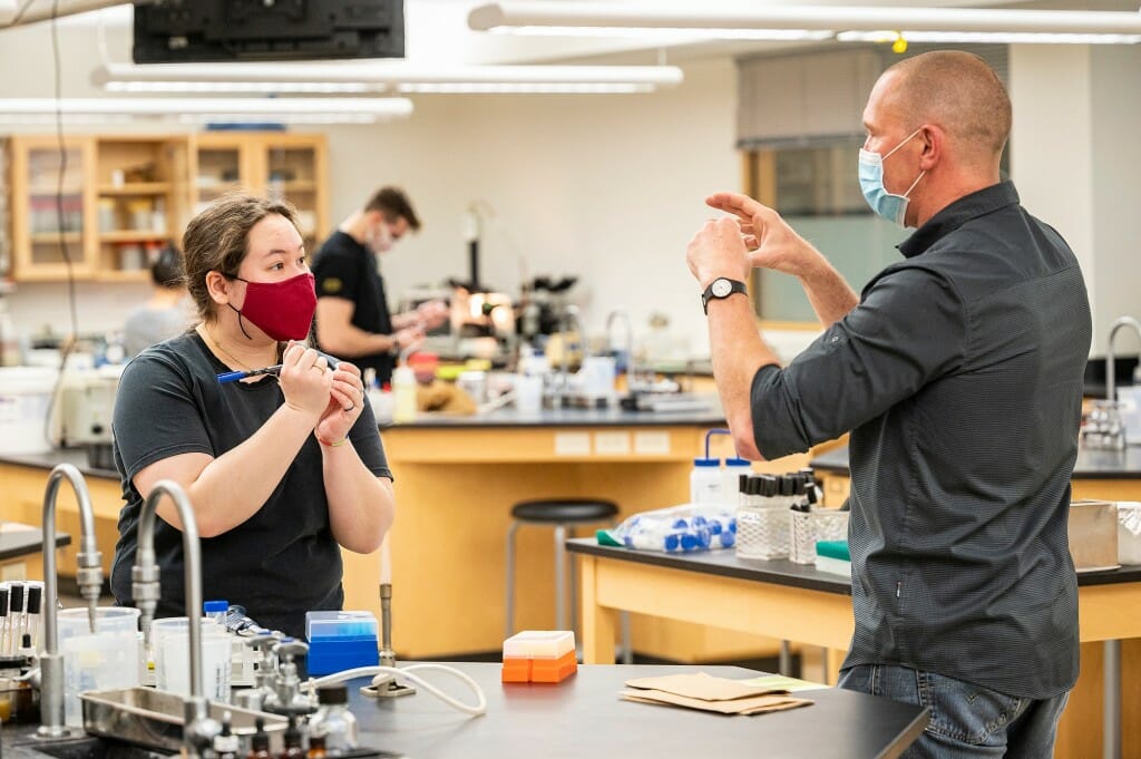 At right, Roll talks with undergraduate Katelyn Major as Major conducts an experiment in Microbiology 304.