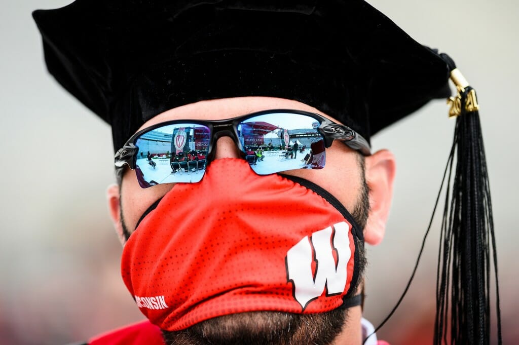 The stage is reflected in a graduate's sunglasses.