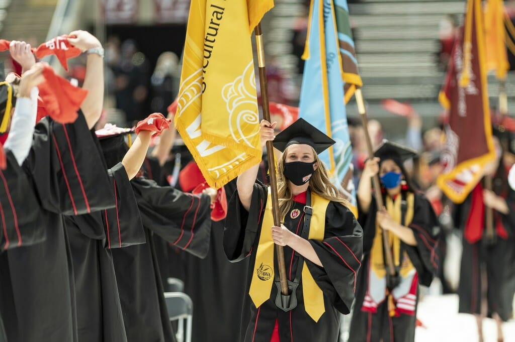 Photo of a graduate carrying the banner of the College of Agricultural and Life Sciences