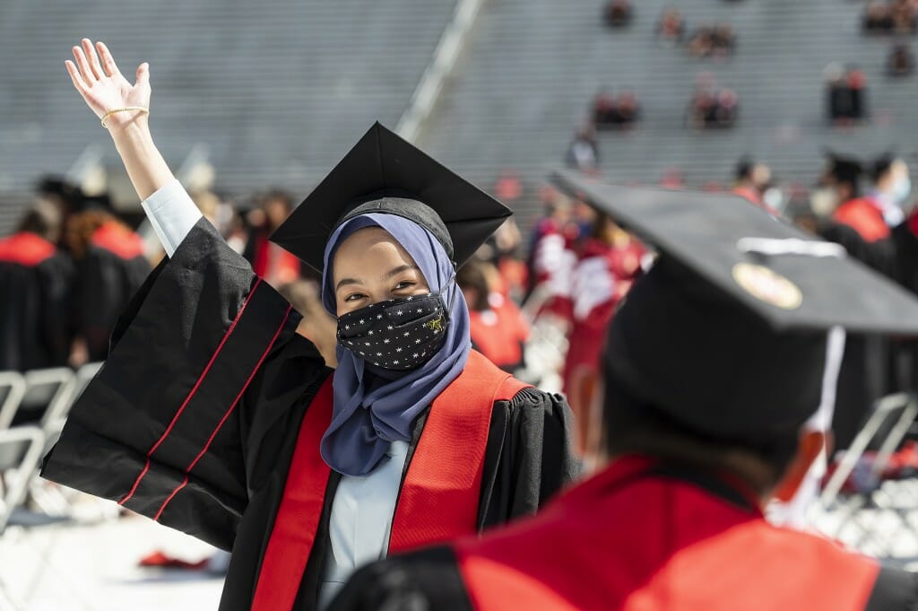Graduate Marshela Mansor waves while posing for a photo
