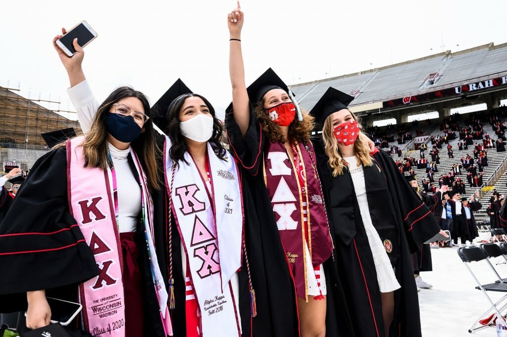 Graduates wearing Kappa Delta Chi stoles join arms to sing "Varsity"