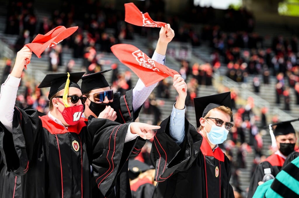 Photo of graduates waving the red rally towels.