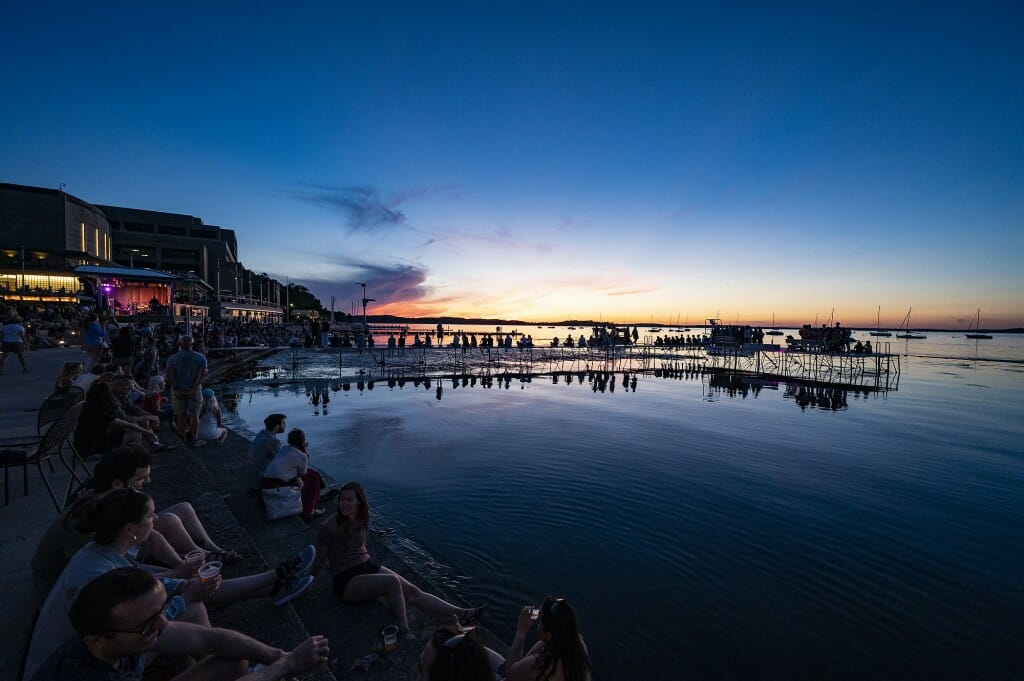People gathered along the shores of Lake Mendota to hear the music.