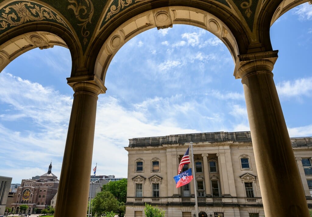 The flag is viewed through the arches of the Memorial Union.