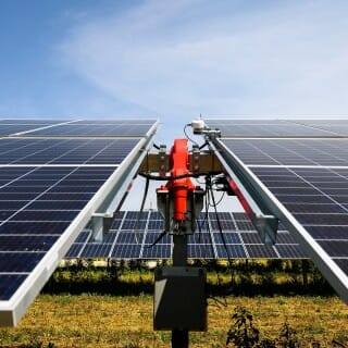 A white and glass-domed pyranometer sensor measures how much sun solar panels are receiving; it's near the motorized pivot point for a row of solar panels. The panels, built by Canadian Solar, will lose capacity at a maximum of 0.5 percent per year and will be assessed in 30 years to see if the lease will be renewed.