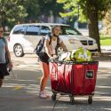 Incoming undergraduate Kate Dekanich and her mother push her essential belongings in a red cart towards Gilman House in Kronshage Residence Hall during the first day of move-in.