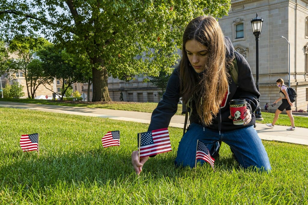 Student Izzy Prenger places an American flag on Bascom Hill.