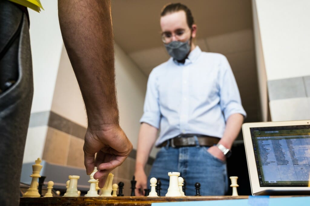 Man playing chess against computer Stock Photo