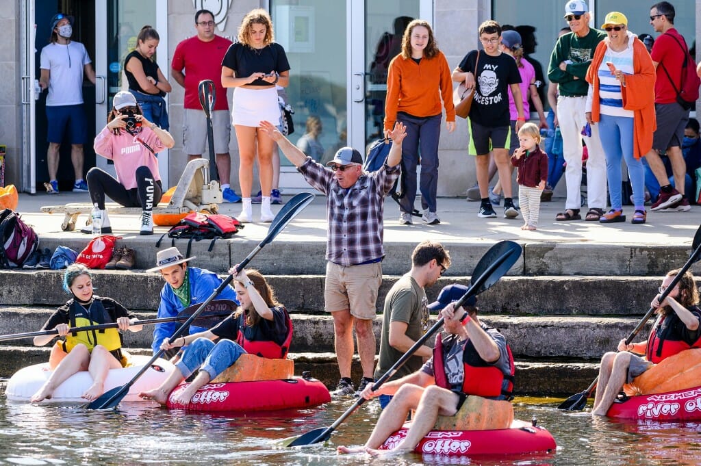 People with oars in pumpkins on the water