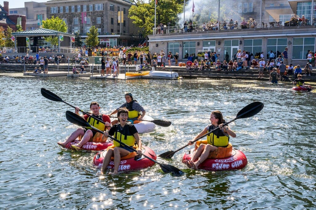 People with oars in pumpkins on the water