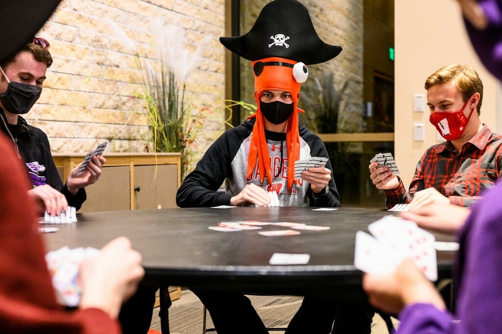 Dressed as a pirate, Riley Colwell plays the card game Spoons – with Wiscards – with other first-year students.
