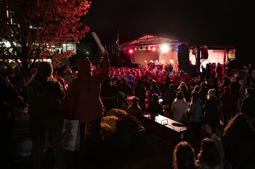 The crowd joins the UW Marching Band in singing of Varsity toward the end of the Homecoming Block Party and Pep Rally at Alumni Park and the Memorial Union Terrace.