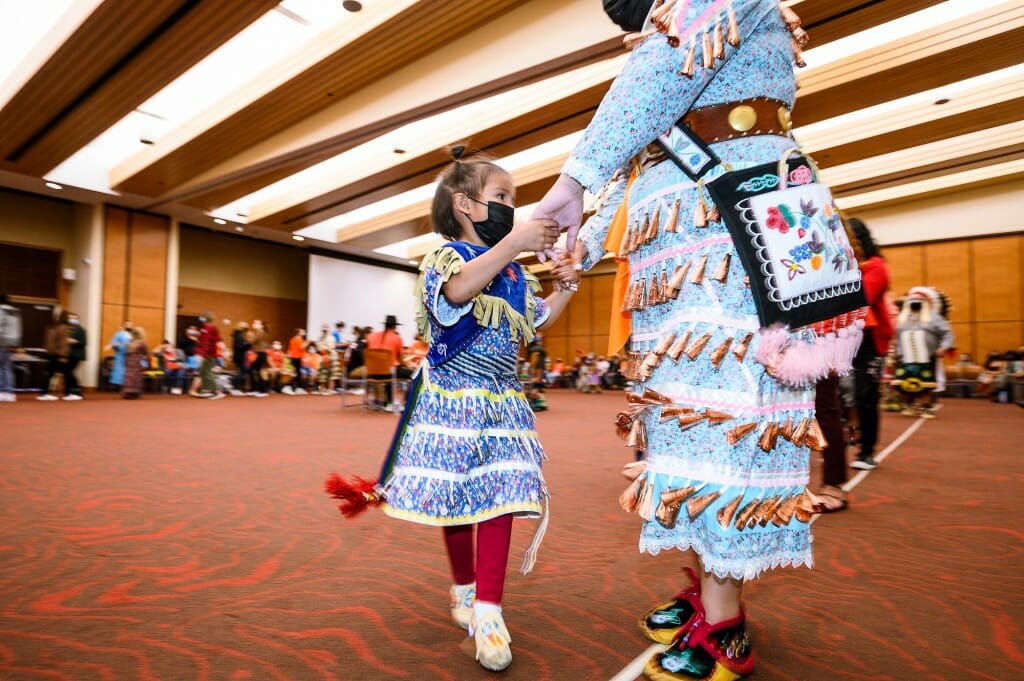 A young girl and woman, Tessa Begay of Lac Courtes Oreilles, dance during the powwow.