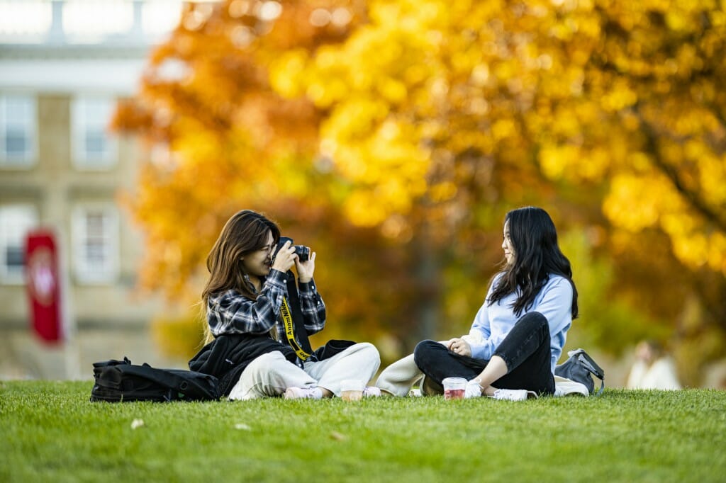 Ahjin Jo composes a photograph of Hayoung Yi posing against a golden backdrop on Bascom Hill. Does her camera have an autumnfocus setting?