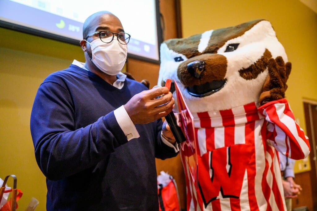 LaVar Charleston, deputy vice chancellor and chief diversity officer, and  Bucky Badger announce a raffle ticket number for a gift-bag prize.