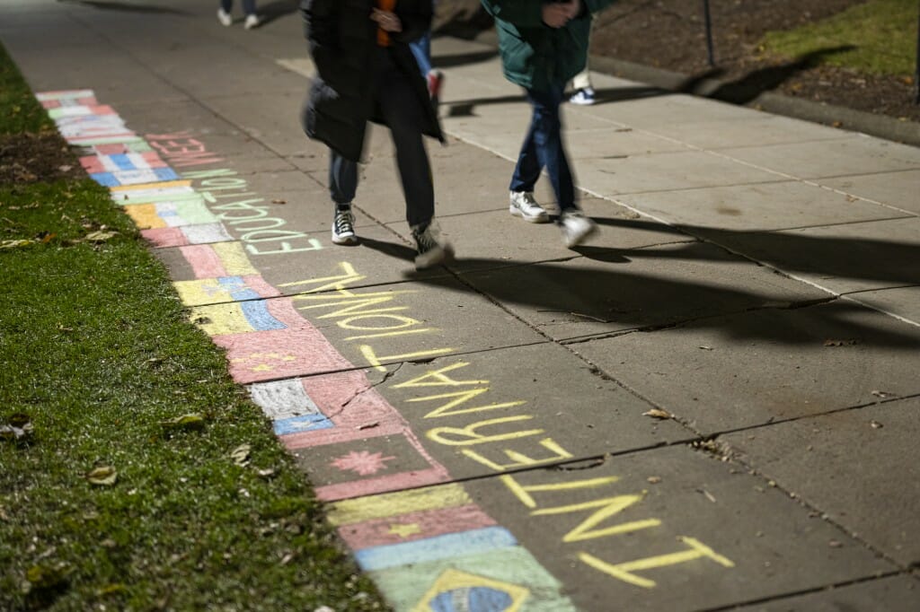 Students walk by a chalk display designed to celebrate International Education Week.