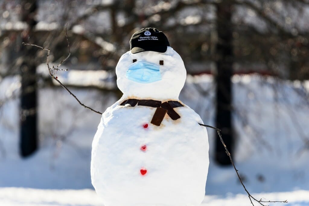 A snowman wearing a disposable face mask