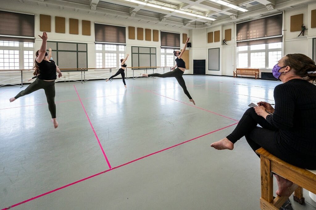 Several students leaping in the air in a dance studio