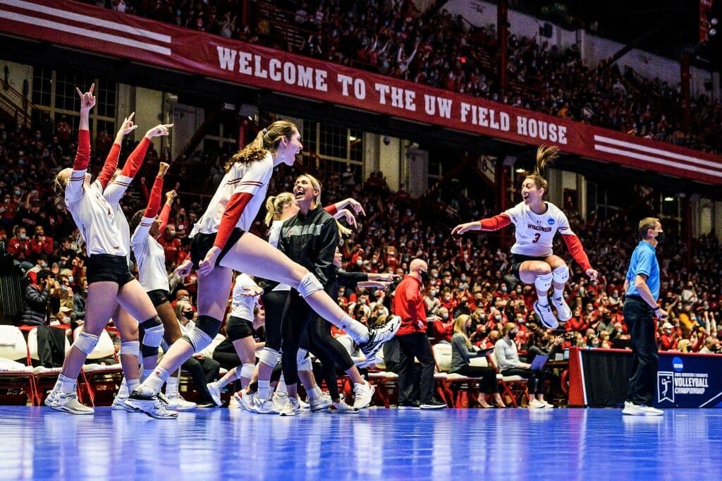 Volleyball players kicking, jumping and running on the court in celebration