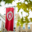A red w-crest banner in front of Bascom Hall
