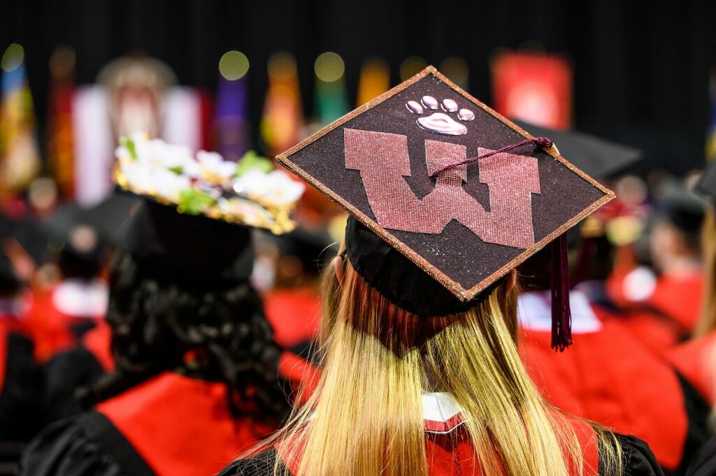 Photo: A cap with a textured UW topped by as paw print.