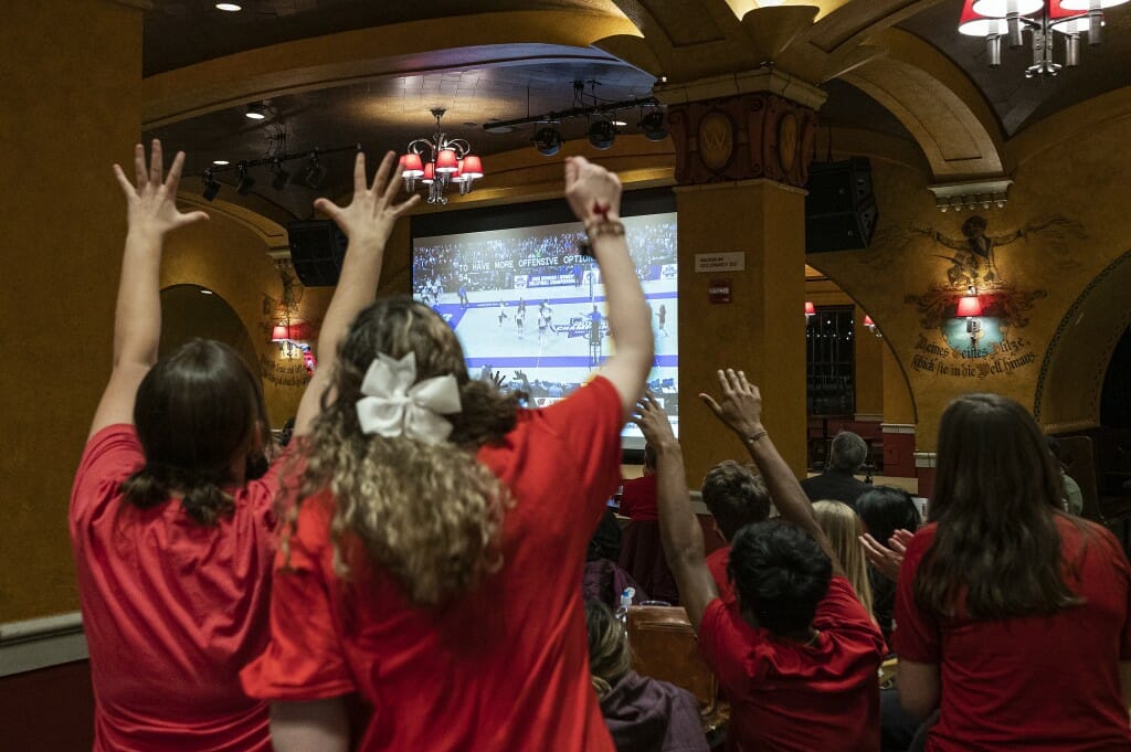 Fans cheer as they watch the NCAA Women’s Volleyball Championship Game on a projection screen at Der Rathskeller.