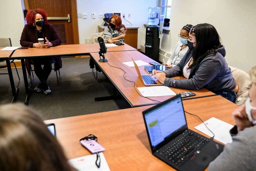 Students with laptops and Hannah-Jones sitting around a table