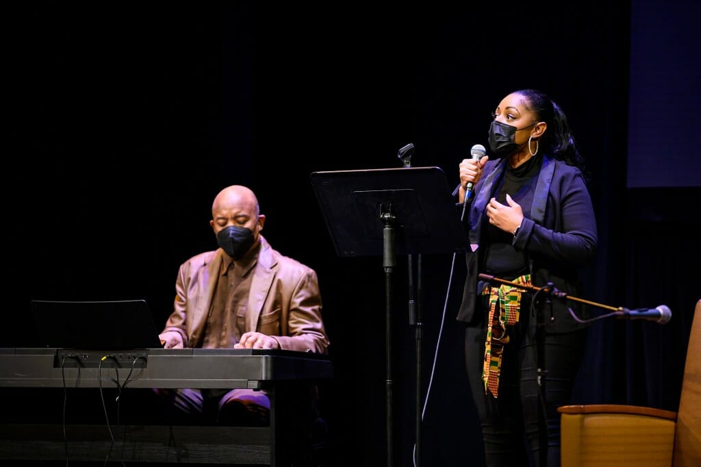 Person playing the piano and another person singing into a microphone