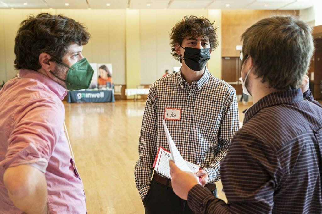 Student Luke Mulligan talks with representatives from the Center for High Throughput Computing at UW–Madison.